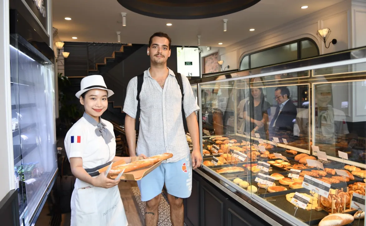 Nhân viên Paris Levain mặc đồng phục thêu cờ Pháp phục vụ khách